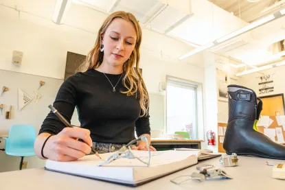 Human centered design student in the studio working on a sketch of a ski boot 