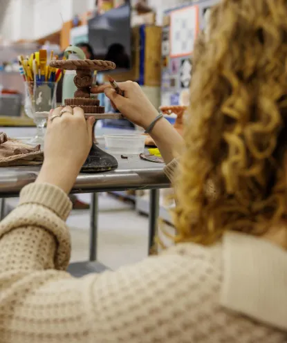 NMU art student working on a ceramics piece